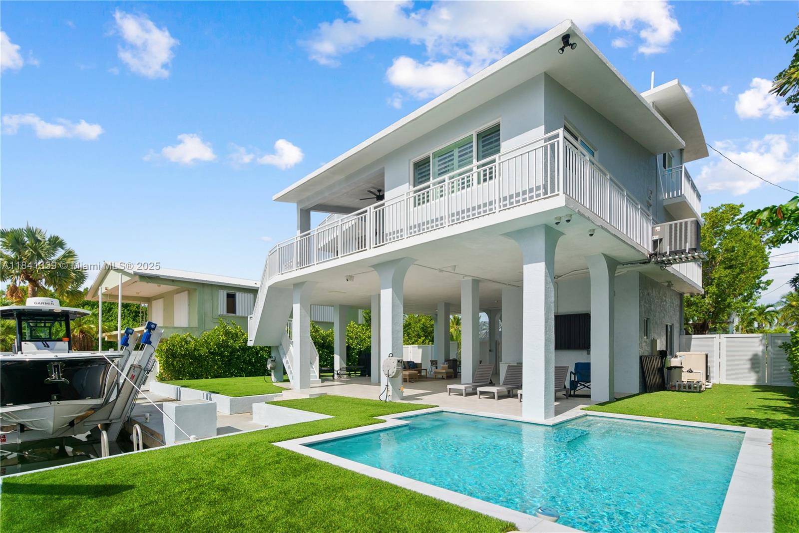 Turnkey Canal Front Pool Home with Immediate Ocean Access! Located just one canal from the open Atlantic, this 4-bedroom, 3-bathroom all-concrete home is a true Keys retreat, complete with 72 ft. of dockage, a 14K boat lift, incredible ocean views and more! Completely updated inside and out, this move-in ready. Spacious primary suite located on the third floor includes a private balcony with panoramic ocean views and an additional guest bedroom, perfect for visitors or a home office. The ground level is built for entertaining, with a large, covered outdoor living space, a new heated pool, full bath, air-conditioned storage, outdoor TVs, full security system & more!