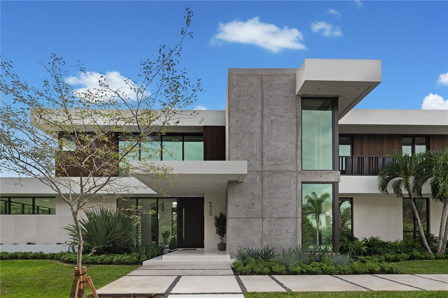 Experience the rare opportunity to own a luxury home in Pinecrest, nearly-new construction completed in 2025. Impeccably maintained, this contemporary estate sits on a 30,492 SqFt (0.7-acre) lot and is truly move-in ready. The current owners are relocating, offering a unique chance to acquire a turnkey modern home without the wait. Designed with both scale and sophistication in mind, the residence features a dramatic double-height great room with a sleek steam fireplace and a custom European chef’s kitchen with Gaggenau appliances. The first level showcases elegant marble flooring and includes two bedrooms with ensuite baths, two powder rooms, and a flexible reading area. Upstairs, the vast primary suite offers a retreat with a spa-inspired bathroom, private sitting area, boutique-style walk-in closet, and morning kitchen. Three additional bedrooms with ensuite baths complete the upper level. Outdoors, enjoy a 53-foot lap pool, expansive backyard, and three-car garage with easy side-street access. This gated property is wrapped in lush landscaping for privacy and offers generous green space for play and entertaining. With 6 bedrooms, 6 bathrooms, 2 powder rooms, and 6,023 SqFt under A/C, this residence delivers an ideal blend of modern design, comfort, and functionality. Located in one of Pinecrest’s most sought-after, family-friendly neighborhoods, just minutes from top-rated schools and parks, this is a standout opportunity to step into refined luxury living in Pinecrest.