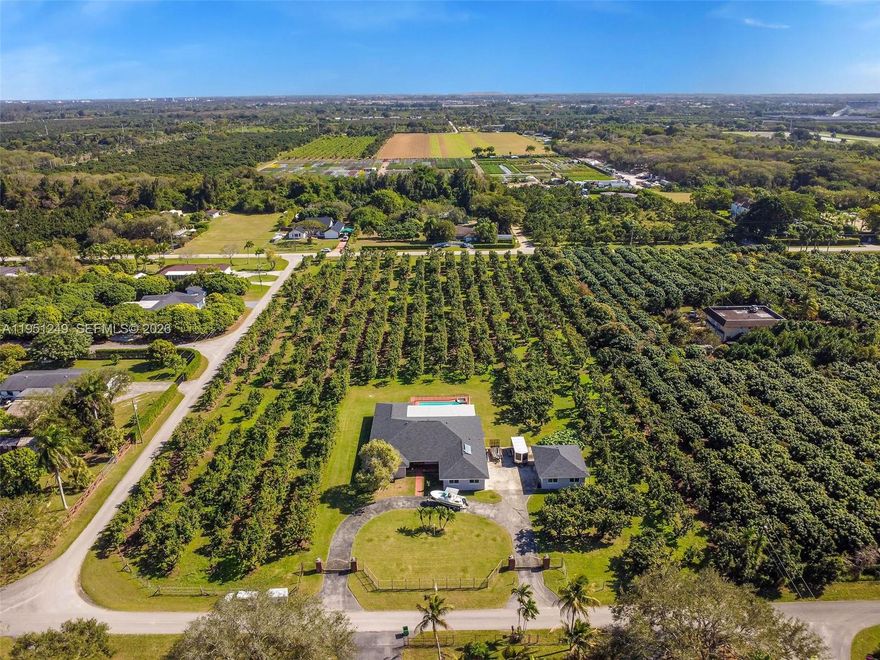 5-acre fully fenced property featuring a gated driveway with two remote-control access gates. The home offers 4 bedrooms and 4 full bathrooms. Spacious living, dining, and family rooms. Outdoor features include a swimming pool with baby safety fence and an extra detached 2-car garage. Interior highlights include a remodeled kitchen (2021) and impact windows throughout. Major upgrades include a new shingle roof (2025). Agricultural-exemption, boasting approximately 500 avocado trees, ideal for agricultural use or income potential.  A rare opportunity offering privacy, space, and functionality.