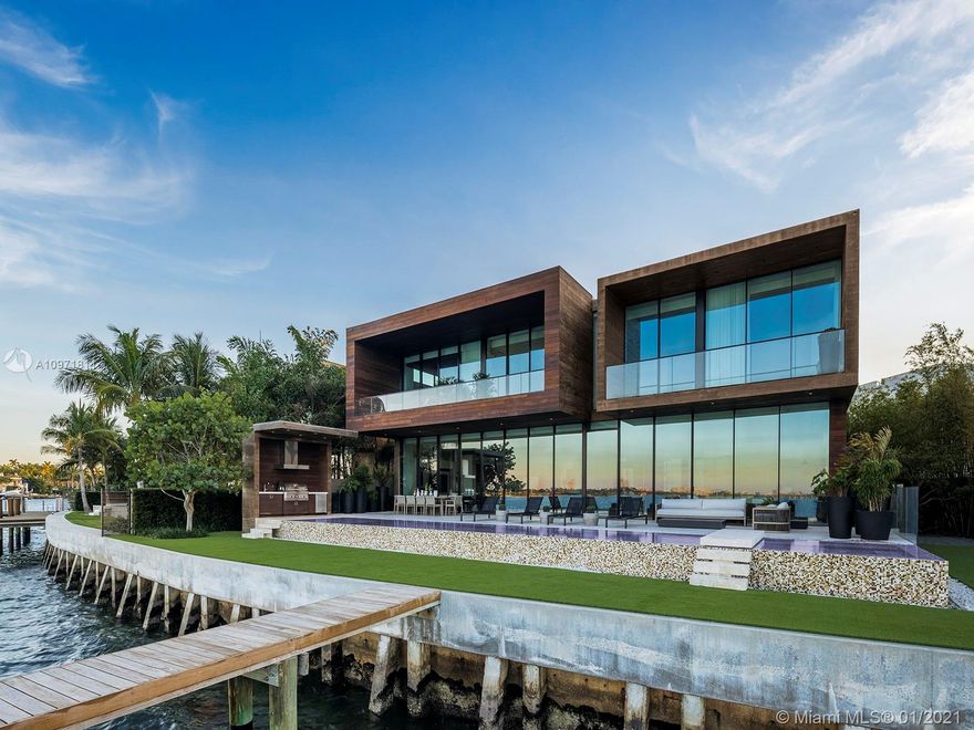 This magnificent Venetian Islands estate has 99 feet of Biscayne Bay frontage, showcased by 12-foot-high retractable Vitrocsa windows that blur the line between inside and out. The sweeping, open-plan interior leads directly to deep terraces, a zero-edge pool with integrated spa, a cabana kitchen, and an Ipe wood dock. Rich materials and bespoke details make the large, 7,112 sq. ft. home feel handcrafted and intimate. The large office features a privacy glass feature and private bath, with courtyard views. Upstairs, two guest rooms feature wide bay views, in addition to the secluded master suite which also offers two balconies, an Ornare closet, and a private gym. The home has been impeccably furnished by Design Solutions and Fisker International with custom pieces by Jader Almeida.