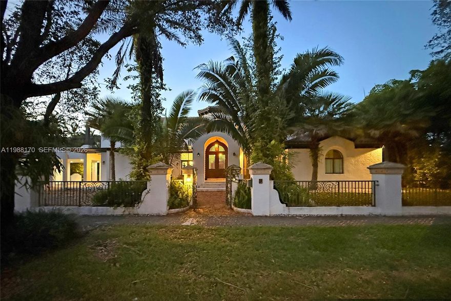Behind wrought-iron gates on one of Coral Gables' finest streets stands a one-of-a-kind Mediterranean estate. Custom-built in 2002, this 6-BD, 6-BA masterpiece offers 6,887 SF on a 19,750 SF lot — where Old World grandeur meets South Florida resort living.
A Moorish-arched portico leads to a breathtaking hand-carved lattice mahogany entry door beneath an amber lantern a work of art before you even step inside. The soaring octagonal rotunda beyond features a hand-painted sky mural, wrought-iron chandelier, travertine floors, coral stone columns, pecky cypress beam ceilings, and a monumental hand-carved travertine fireplace.
The chef's kitchen opens to pool views. A full-width covered loggia with wood-plank ceiling bridges interior and exterior living seamlessly. The resort pool features LED lighting, a cascading waterfall wall, and a travertine deck surrounded by lush tropical landscaping. A private turf sports court and dedicated fitness room with all exercise equipment included complete this extraordinary compound.
Two kids' suites connect through a shared loft play and study space — a magical private world for young ones. Six generous suites total, hand-painted ceiling murals, Portuguese-tile baths, and rich mahogany millwork throughout. Minutes to Miracle Mile, Merrick Park, and MIA.