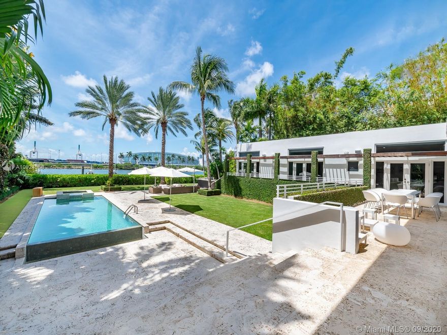 This stunning gated WATERFRONT 2-story MODERN home+guest house on guard-gated Palm Island lies on an expansive 27,500 SF LOT w/100’of waterfront which overlooks Biscayne bay&the Miami skyline.Home offers 7 bed+7.5 bath,impact windows throughout,open spaces through the formal living rm&dining rm w/double height ceilings,updtd kitchen w/subzero&wolf appliances,3 beds w/ensuite bths,family room+views of the outside area which features a large edge pool+summer kitchen.Stairs to the master suite,w/private terrace.Separate 2 story guest home features 3 full beds w/ensuite baths as well as an additional room&laundry space.4 car grg+additional parking space inside.Palm Island has new landscape plan&features 24/7security,park,lighted tennis courts&more, the ideal location for a family!