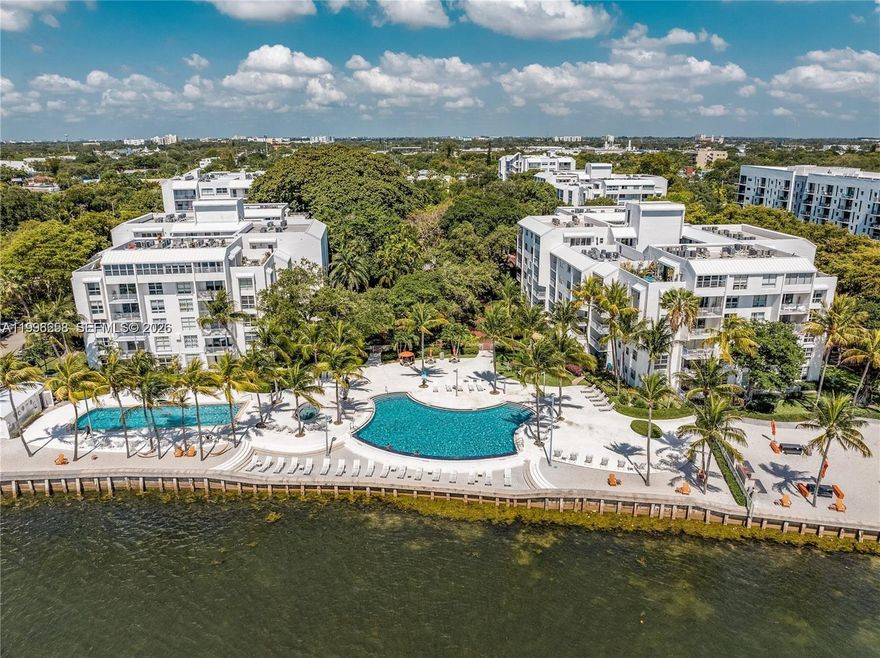 Not your typical condo—this is Nirvana with soul. A north-facing 2BD/2BA retreat where architecture meets atmosphere. Nearly 1,000 SF of open, flowing interiors center around an updated island kitchen, spilling into a living space that feels more like an artist’s loft than a standard residence. Step outside and you’re immersed in a canopy of mature oaks—your private terrace reading like a treehouse suspended in green. Quiet, layered, cinematic. The interiors embrace a more expressive, less over-designed aesthetic—clean tile floors, two full bathrooms, and a layout that invites personalization and creativity. Beyond your door: banyan-lined pathways, two pools, bayfront beach access, kayak and paddleboard storage, sauna, fitness center, and a neighborhood market—all within a guard-gated tropical enclave in the heart of the MiMo District, adjacent to shops, restaurants, waerfront parks and the renowned Farmer's Market. For the buyer who wants feeling over formula.