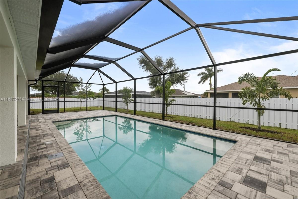$15,000 BUILDER PAID CLOSING COSTS! SPACIOUS SCREENED-IN POOL HOME WITH A PRIVACY FENCE AND DUAL PRIMARY SUITES! This Spacious Pool Home features 4 large beds, 3 baths, Two Primary Suites! Step inside and experience the open-concept great room, highlighted by a 12-foot triple slider that seamlessly connects indoor living to the expansive lanai and heated pool. Gourmet kitchen is a chef’s delight with walk-in pantry. Built by a trusted local builder, this home offers incredible value in Cape Coral. Plus, enjoy peace of mind with a 10-year structural warranty, NO FLOOD ZONE + IMPACT WINDOWS = LOW INSURANCE COSTS. This is The Paradise Cove Plan.