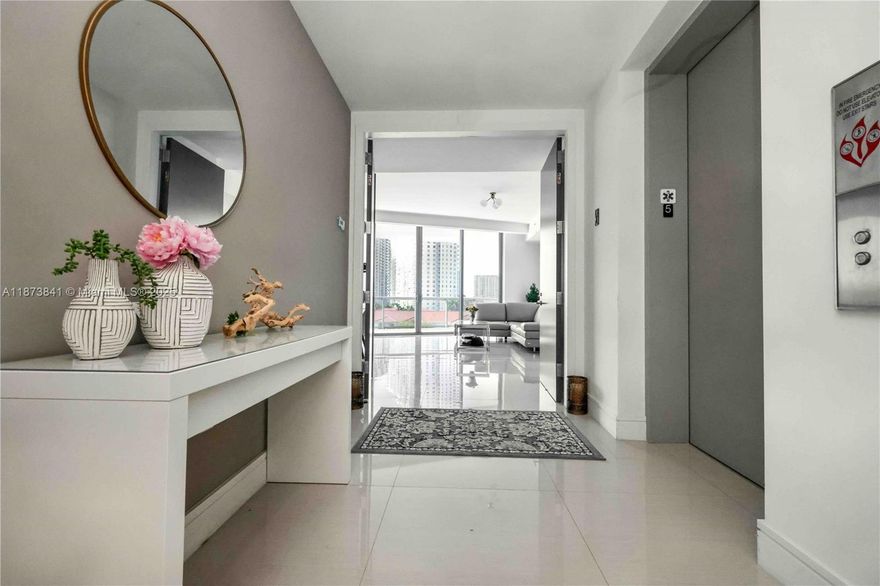 Experience modern elegance in this rarely lived-in residence with stunning water views. This spacious condo features a designer kitchen with marble countertops, waterfall island, high-end cabinetry, and premium appliances. Floor-to-ceiling impact windows bring abundant natural light, complemented by automated electric shades in every room for comfort and privacy. Bathrooms are enhanced with luxury electric bidets, and the walk-in closets have been fully upgraded with premium wood finishes. A unique floor-to-ceiling shoe closet offers stylish organization. Located on the quiet side of the building, the home ensures peace and tranquility. Enjoy expansive balconies for entertaining and resort-style amenities including pool, fitness center, and 24-hour concierge. Pet walking and house car.