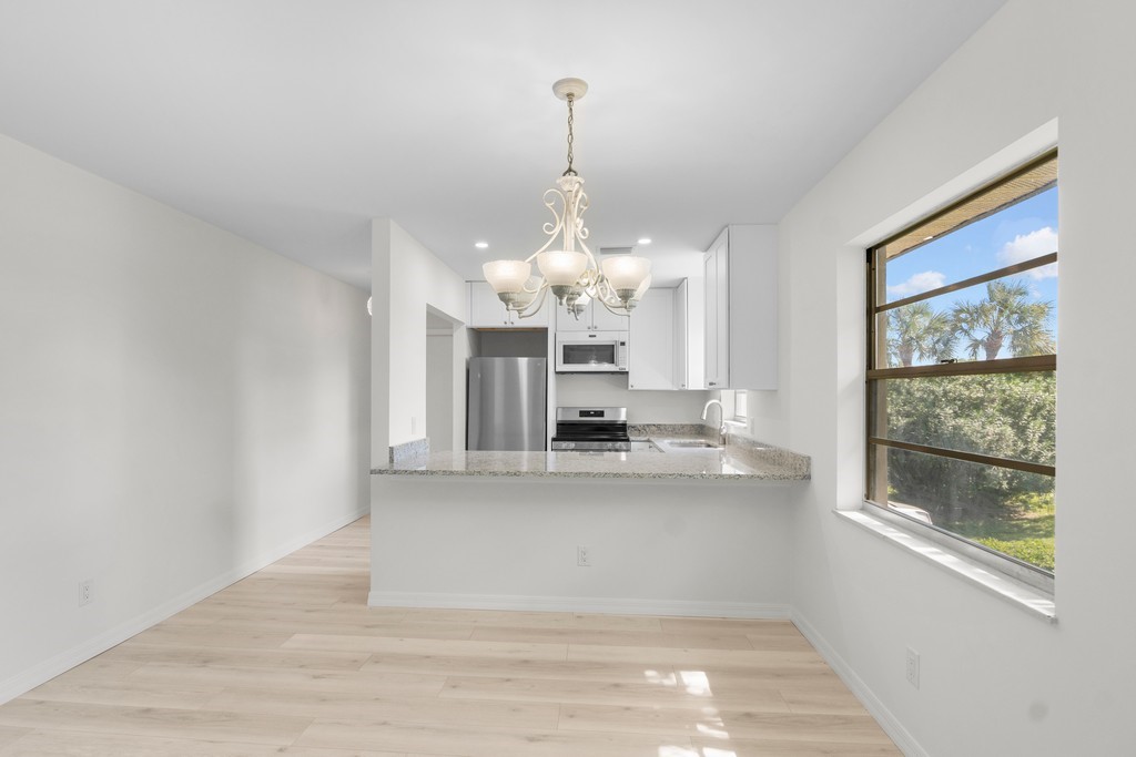 Kitchen with a peninsula, light stone countertops,