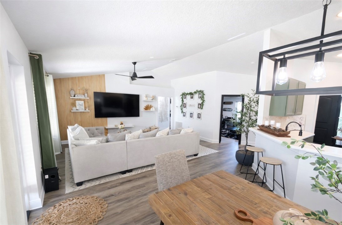 Living area featuring lofted ceiling, dark wood-ty