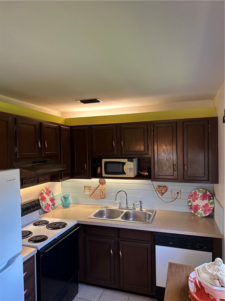 Kitchen featuring dark wood cabinetry, a double ba