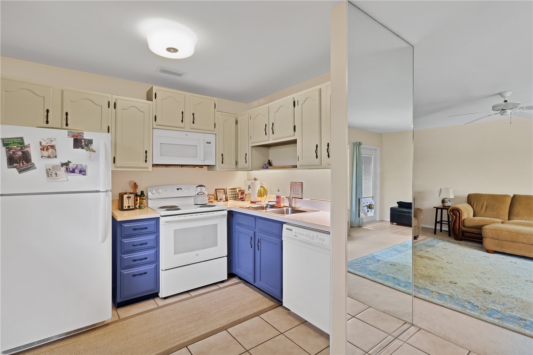 Kitchen featuring neutral upper cabinetry, blue lo
