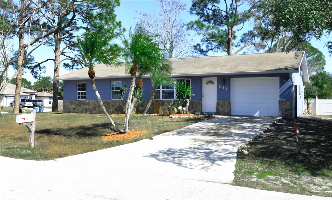 Single story home featuring stone siding, concrete