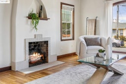 Living area with a brick fireplace, plenty of natural light, and wood finished floors