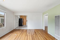 Hardwood flooring throughout a bright room with a single window