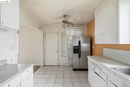 Kitchen featuring white cabinetry, tile countertops, and a tile backsplash