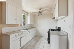 Kitchen featuring white cabinetry, tile countertops, and a white tile backsplash