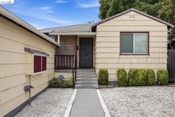 Exterior featuring horizontal siding, a covered front porch, and a gravel front yard