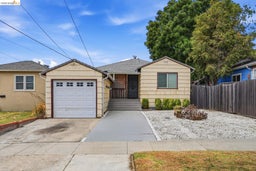 Single-story residence featuring a one-car garage, concrete driveway, and a gravel front yard