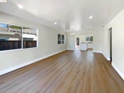 Unfurnished living room with light wood-type flooring, a chandelier, and recessed lighting