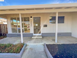 Doorway to property with covered porch and board and batten siding
