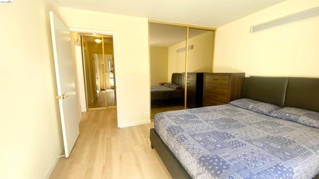 Bedroom featuring wood-finish flooring, light-toned walls, and a recessed ceiling light fixture