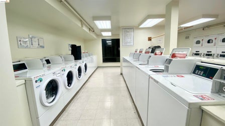 On-site laundry facility featuring multiple front-loading and top-loading washing machines