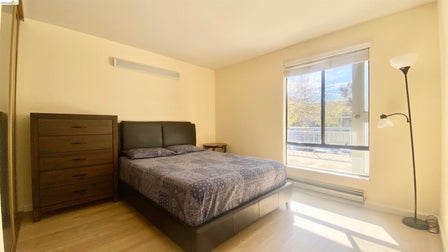 Bright interior space featuring a large window, light-toned walls, and wood-finish flooring
