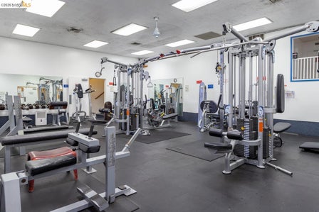 Fitness center featuring multiple exercise machines, weight equipment, rubber flooring, and mirrored walls