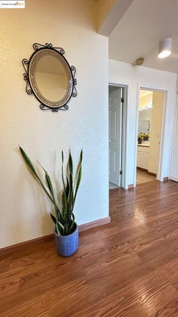 Hall featuring wood finished floors and a textured wall