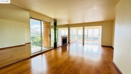 Unfurnished living room with healthy amount of natural light, a textured ceiling, wood finished floors, and a fireplace