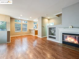 Unfurnished living room featuring wood finished floors, a glass covered fireplace, and recessed lighting
