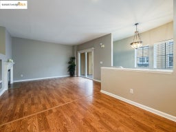 Unfurnished living room featuring wood finished floors and a glass covered fireplace