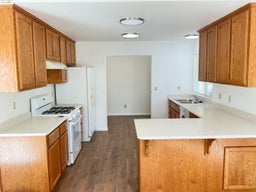 Kitchen with gas range gas stove, light countertops, a kitchen bar, and a peninsula