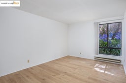 Unfurnished room with a baseboard heating unit and light wood-type flooring