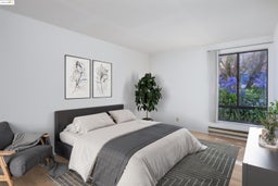 Bedroom with light wood finished floors and a baseboard heating unit