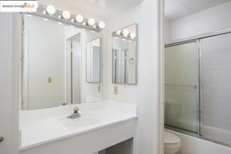 Bathroom with vanity and bath / shower combo with glass door