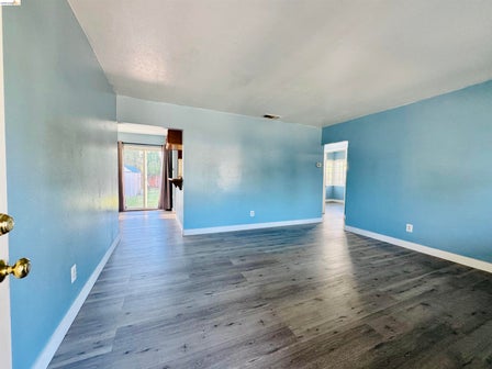 Spacious interior featuring wood-finish flooring, light blue wall finishes, and white trim
