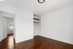 Unfurnished bedroom featuring dark wood finished floors and a closet