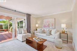 Carpeted living area featuring ornamental molding and baseboards