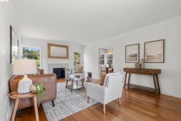 Living room with a fireplace with flush hearth, healthy amount of natural light, and light wood finished floors