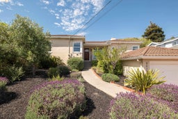 View of front facade featuring stucco siding, an attached garage, and a tiled roof