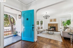 Entrance foyer featuring wood finished floors, crown molding, a fireplace, a chandelier, and arched walkways