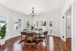 Dining space featuring dark wood-style flooring, plenty of natural light, and a chandelier
