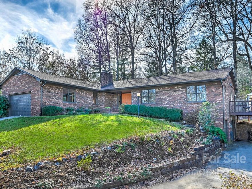 So much modern charm in this beautifully updated Swannanoa ranch home! Enter into a spacious open floorplan with updated kitchen, bathrooms, luxury vinyl tile and new carpeting in the bedrooms. Cozy up in the living room beside the wood-burning fireplace on a chilly night. Step outside to a large rear and side deck with hot tub giving you plenty of room for entertaining guests. Head downstairs into the potential 2nd living quarters with a kitchenette, family room with fireplace, bedroom and bathroom. Features plenty of parking with main level two car garage and two-car basement garage with separate entrance. Low maintenance brick exterior, two driveway access, RV parking with 50 amp plug and water connection plus a Generac natural gas whole house generator. Located minutes from downtown Asheville and Black Mountain, Blue Ridge Parkway and 5 minutes to the Warren Wilson trail systems.