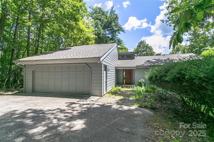 Spacious 3BR/2.5BA home in the gated Connestee Falls community! Surrounded by nature, this home offers privacy and a filtered golf course view. Inside, enjoy hardwood floors, vaulted ceilings, a stunning stone fireplace, and walls of windows that fill the living space with natural light. The kitchen features ample cabinet space and updated appliances. Multiple living areas open to expansive decks, a screened porch, and a lower-level workshop with room to expand. Two-car garage, wooded lot, and access to community amenities including trails, lakes, golf, and more.