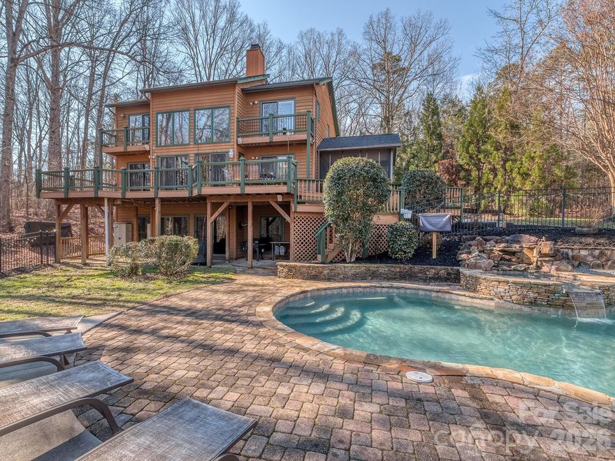 Nestled in the woods outside of Waxhaw, this stunning contemporary cabin-style home on 5.76 acres offers the perfect blend of rustic charm and modern luxury. The exterior features a striking combination of wood siding and brick, with a spacious screened porch and expansive deck overlooking a resort-style pool with hot tub. Inside, soaring ceilings and walls of windows flood the open-concept living area with natural light, highlighting the warm wood paneling and stone fireplace. The gourmet kitchen boasts sleek white cabinetry, stainless appliances, and a stylish tile backsplash. With multiple bedrooms, updated bathrooms, and a walk-in closet, this home provides ample space for comfortable living. The fully finished walk-out basement offers plenty of room for entertaining with a kitchenette, bonus room, office and library.  The home features an auto on/off whole house generator and a detached 542-sf workshop. Enjoy the serene, wooded setting while being just minutes from Waxhaw's quaint downtown, excellent schools, and convenient shopping. This unique property offers the best of both worlds - peaceful seclusion and easy access to urban amenities.