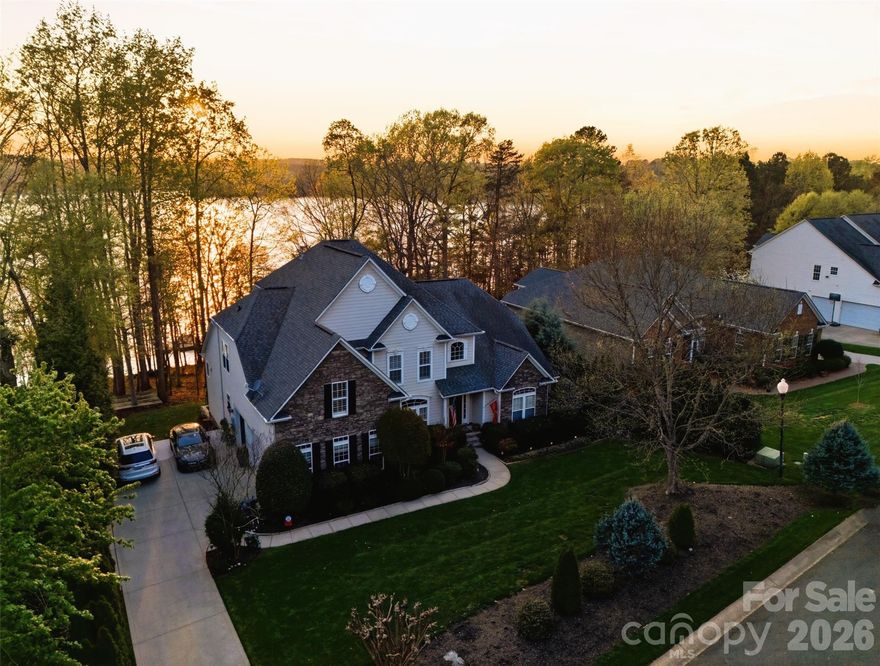 Welcome to waterfront luxury living with a private dock in Stonewater, one of the most desirable communities in Mountain Island Lake. Perfectly positioned, this exceptional 4-bedroom, 4.5 bath waterfront residence offers a lifestyle defined by elegance, comfort, and connection to the outdoors, complete with a private boat dock and slip. From the moment you enter, you're greeted by refined details and a sense of effortless sophistication. The main level showcases hardwoods and a light-filled, open concept design. The chef's kitchen is a true showpiece, featuring high-end Monogram built-in appliances, a large center island, custom tilework, pantry and a stylish laundry room for refined functionality. The space flows effortlessly into the main living areas with high ceilings and a sunlit breakfast room which opens to a relaxing deck area. The spacious primary suite is on the main floor with new, premium plush carpeting - includes a sitting room, a spa-like shower and soaking tub, and two walk-in closets. The main floor also includes a generous executive style office, a traditional dining room and a half-bath. Upstairs, you will find three additional bedrooms with new, premium plush carpeting - one private ensuite and two bedrooms that share a jack-and jill bathroom layout. The walk-out basement expands the home's living spaces with new LVP flooring, offering endless possibilities for recreation, entertaining, or multi-generational living, and includes an additional full bathroom. A 3-car garage also adds convenience and additional storage. Living in Stonewater extends beyond your doorstep offering residents resort-style amenities including a clubhouse, pool, lakefront walking trails, kayak and paddleboard storage, playgrounds, basketball, volleyball, tennis and pickleball courts - all within a beautifully maintained community. Just minutes to the airport, the Whitewater Center and Uptown, offering the perfect balance of convenience and peaceful lake living. This is more than a home. It's where luxury meets lifestyle- and where every day feels like a retreat.