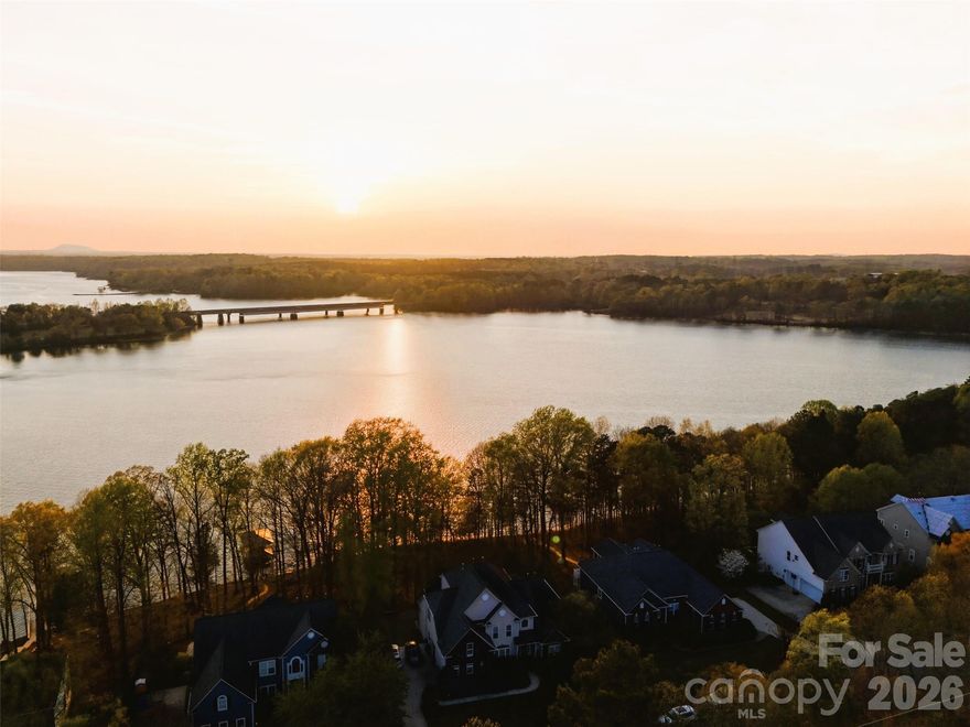 Welcome to waterfront luxury living with a private dock in Stonewater, one of the most desirable communities in Mountain Island Lake. Perfectly positioned, this exceptional 4-bedroom, 4.5 bath waterfront residence offers a lifestyle defined by elegance, comfort, and connection to the outdoors, complete with a private boat dock and slip. From the moment you enter, you're greeted by refined details and a sense of effortless sophistication. The main level showcases hardwoods and a light-filled, open concept design. The chef's kitchen is a true showpiece, featuring high-end Monogram built-in appliances, a large center island, custom tilework, pantry and a stylish laundry room for refined functionality. The space flows effortlessly into the main living areas with high ceilings and a sunlit breakfast room which opens to a relaxing deck area. The spacious primary suite is on the main floor with new, premium plush carpeting - includes a sitting room, a spa-like shower and soaking tub, and two walk-in closets. The main floor also includes a generous executive style office, a traditional dining room and a half-bath. Upstairs, you will find three additional bedrooms with new, premium plush carpeting - one private ensuite and two bedrooms that share a jack-and jill bathroom layout. The walk-out basement expands the home's living spaces with new LVP flooring, offering endless possibilities for recreation, entertaining, or multi-generational living, and includes an additional full bathroom. A 3-car garage also adds convenience and additional storage. Living in Stonewater extends beyond your doorstep offering residents resort-style amenities including a clubhouse, pool, lakefront walking trails, kayak and paddleboard storage, playgrounds, basketball, volleyball, tennis and pickleball courts - all within a beautifully maintained community. Just minutes to the airport, the Whitewater Center and Uptown, offering the perfect balance of convenience and peaceful lake living. This is more than a home. It's where luxury meets lifestyle- and where every day feels like a retreat.