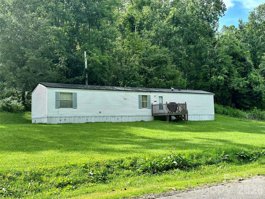 Price cut $8k on this Affordable mountain retreat in the heart of nature. 1.43-acre property offers a peaceful haven minutes from Little Switzerland, the Blue Ridge Parkway, Mt Mitchell. Surrounded by national forest & park lands, Ideal setting for full-time living, a relaxing vacation getaway or a lucrative VRBO.  Well-maintained 14’x66' home built in 1994, features 3-bedrooms, 2-full baths, A spacious master suite that easily accommodates a king-size bed. Open living room & kitchen concept; Central HAVC for year-round comfort, Durable metal roof. All appliances included, so you can move in with ease. Outside you’ll immediately appreciate the gentle, usable land—perfect for a garden, pets or a few farm animals. Across the quiet road, a babbling creek provides a soothing soundtrack to your daily life-the peaceful sound adds a calming touch to a serene setting. No restrictions, Versatile property ready for whatever you envision. Explore the possibilities & experience the quiet charm of mountain living