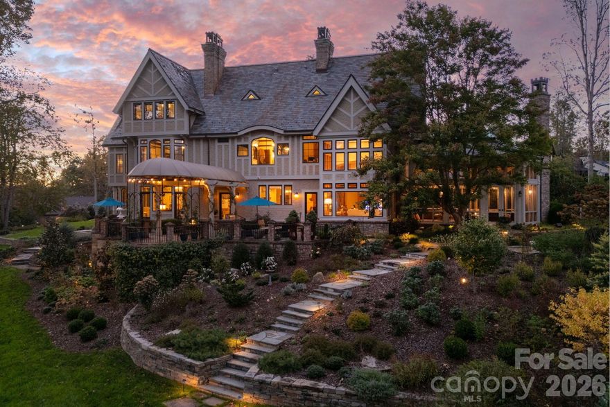 Welcome to 8 Fairway Place—a residence where timeless architecture meets refined living in one of Asheville’s most sought-after communities. Inspired by French chateau elegance with subtle Tudor influences, this Griffin Architects, PA home offers both grandeur and comfort, just steps from the 7th fairway of the exclusive Biltmore Forest Golf Course. The entry hall is graced with William Morris–inspired stained-glass windows and a painted strap work ceiling that highlight the home’s history and artistry. An Edwardian sunroom/parlor, filled with natural light and set with terracotta flooring, creates an inviting space for relaxation. The formal dining room features stenciled Venetian plaster and a high ceiling adorned with a decorative plaster English rose motif. The butler’s pantry, with its backlit English Art Nouveau antique stained-glass doors, opens to an expansive terrace. At the heart of the home, the soaring great hall is anchored by a striking stone fireplace framed in handcrafted woodwork—a space that is both a dramatic showpiece and a warm gathering place. Just beyond, the screened-in porch extends the living area and offers panoramic views of the lush golf course. The grounds are as breathtaking as the interiors, with thoughtful landscaping that provides year-round color and texture. Stone retaining walls and winding pathways echo the craftsmanship found throughout the home’s design. From sunlit interiors to serene outdoor spaces, every detail at 8 Fairway Place reflects timeless elegance and effortless living. Space for Buyer to put in an elevator.More than a home, it is a lifestyle defined by sophistication, community, and the natural beauty of Biltmore Forest. View the tour: bit.ly/8Fairway