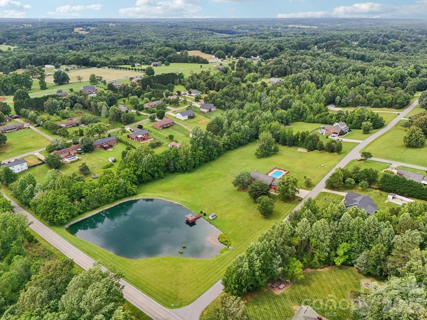 Nestled in Mason Springs on 5.86 acres, this property offers the perfect opportunity to add your personal touch — all with NO HOA. Relax on the covered front porch overlooking the fully stocked pond, ideal for fishing or enjoying the peaceful scenery as ducks drift across the water.

Inside, the living room features a vaulted ceiling and stone fireplace. The kitchen is equipped with stainless steel appliances, an electric range, and opens to the dining area with direct access to the back patio. Just off the kitchen, you’ll find a laundry room with a sink for added convenience.

The primary suite includes dual walk-in closets and balcony access. The ensuite bath features a soaking tub, walk-in shower, and double vanity. Two additional bedrooms and a full bath complete the main level.

Downstairs, the fully finished basement expands the living space with a full second kitchen, full bathroom, and an impressive 53’ x 18’ recreation room complete with a pool table and fireplace. Two additional versatile rooms provide endless possibilities for a home office, gym, hobby space, guest accommodations or multigenerational living.

Step outside to enjoy the fully enclosed patio and inground freshwater pool, creating the perfect setting for entertaining or unwinding in privacy. For added peace of mind, there is a transferrable Choice Home Warranty (Total Plan) on the property through 9/2027.

Enjoy the ideal blend of peaceful country living and everyday convenience with nearby shopping, local dining, parks, and outdoor recreation just minutes away, while still maintaining easy access to Denver, Lake Norman, and Charlotte.
