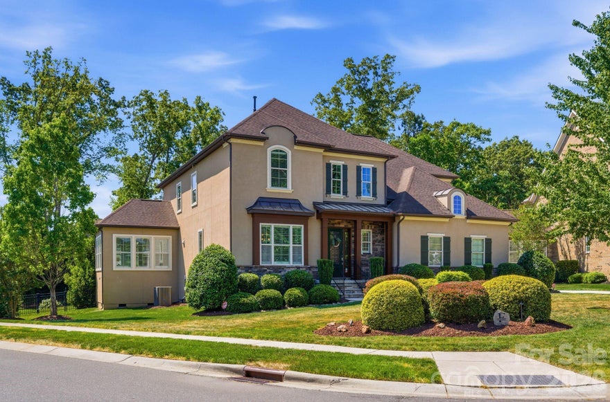 Positioned on a 0.50-acre corner homesite in Weddington Trace, 1414 Smoketree Court presents a six-bedroom residence in one of Waxhaw's established communities, offering a main level guest suite, open concept living and a well executed indoor outdoor design. A welcoming foyer introduces hardwood flooring and custom plantation shutters that extend throughout the main level, reinforcing both design continuity and natural light control. To the left, the dining room is defined by a tray ceiling, while the staircase to the right leads to an upper level princess landing overlooking the entry, contributing to the home’s open architectural feel. A mudroom and drop zone connect directly to the 3 car garage, creating a functional transition for daily living. The family room is anchored by a gas fireplace and flows seamlessly into the kitchen, supporting connectivity across the primary living spaces. The kitchen is designed with both scale and efficiency in mind, featuring a substantial center island, double wall ovens, a five burner gas range and a butler’s pantry with custom built-ins and an ice maker, aligning with expectations for a luxury kitchen in today’s market. A sunroom just off the dining area introduces natural light and extends the living footprint. The main level guest suite, currently utilized as an office, offers flexibility for multigenerational living or remote work and includes a rear wall of modular office cabinetry with integrated drawer storage, allowing for adaptable workspace configuration. A full bath with hall access serves this space, supporting both guest accommodations and everyday functionality. Each secondary bedroom is well proportioned, providing separation and comfort. Two bedrooms are connected by a Jack and Jill full bath, while an additional bedroom features a private en suite bath. The primary suite is scaled for comfort and includes a tray ceiling, crown molding and a walk-in closet with built-ins. The en suite bath is appointed with dual vanities and a garden tub. An upper-level bonus room offers flexibility as a media room, additional bedroom or multipurpose space depending on lifestyle needs. Outdoor living is a defining element of the property. A three-season porch transitions to a dedicated entertaining area, where a pebble finish saltwater pool and Jacuzzi position the home among Waxhaw properties offering private outdoor living and resort style amenities. Community amenities include a junior Olympic swimming pool, splash pool, tennis courts, pickleball courts, basketball court, walking trails, pond and dock. The property’s corner positioning and proximity to a natural pocket park across the street contribute to the overall setting, privacy and neighborhood appeal. Conveniently located approximately 6 miles from Interstate 485, the home provides access to regional connectivity while maintaining a residential setting. Everyday conveniences, including Publix at Marvin Gardens, are located approximately 2 miles away. Rea Farms and Waverly are both within approximately 5 miles, offering dining, retail and lifestyle services. Several private country clubs and golf courses are also located within a short drive.
The property is currently zoned for Cuthbertson schools. Buyers are encouraged to verify school assignments.